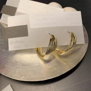 Fashionable gold twisted geometric hoop earrings with layered metal lines for women