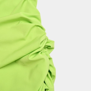 Detailed close-up showing the soft texture and draped fluorescent green fabric