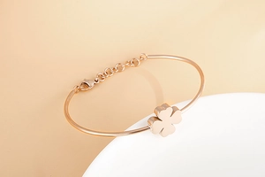 Close-up of rose gold clover bracelet with adjustable chain and lobster clasp