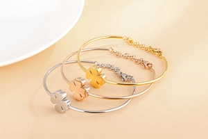 Detailed view of adjustable clover bracelets in gold, rose gold, and silver stainless steel