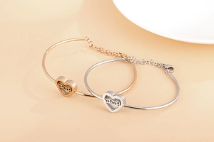 Detail of mama heart-shaped adjustable bracelets in rose gold and silver finishes