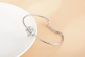 Détail du bracelet arbre de vie avec fermoir mousqueton posé sur un plat en céramique