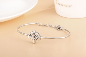 Détail d'un bracelet arbre de vie en argent avec fermoir ajustable sur fond beige