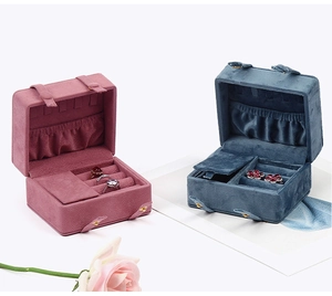 Pink and blue velvet travel jewelry boxes with interior slots for rings and necklaces