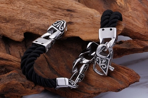 Macro detail of men's braided nylon bracelet with engraved stainless steel totem clasp