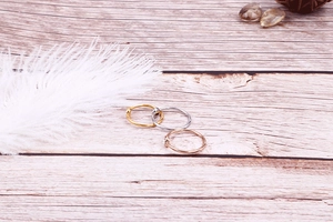 Detailed view of three minimalist rings in gold, silver, and rose gold with tiny zircons