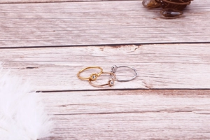 Detailed view of minimalist gold, rose gold and silver rings with small single zircon