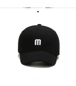 Detailed front view of black baseball cap featuring 3D white embroidered letter M