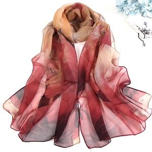 Detail view of red and camel lotus print silk scarf with luxury floral line patterns