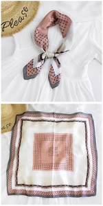 Close-up of elegant geometric print silk scarf in pink and grey showing texture and pattern