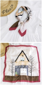 Detail of elegant beige silk square scarf with red trim and cafe illustration pattern