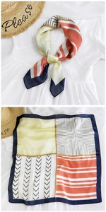 Detail of a geometric silk scarf featuring orange and navy patchwork patterns