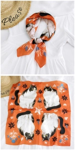 Detail of orange square silk scarf with cat and flower print over lace background