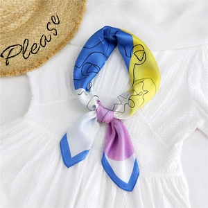 Elegant multicolored silk-like scarf with abstract line art tied in a bow over a white top