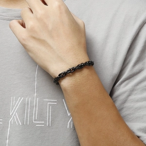 Close-up of a matte black stainless steel double-link chain bracelet on a male wrist
