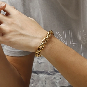 Close-up of a gold double-buckle chunky chain bracelet worn on a male wrist