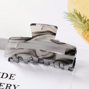 Macro shot of large marble pattern hair claw clip with black and white acetate texture