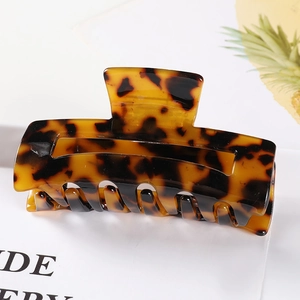 Detail view of large tortoiseshell hair claw clip with amber texture and secure teeth