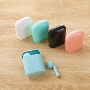 I7mini auriculares Bluetooth inalámbricos coloridos en cinco tonos pastel sobre madera