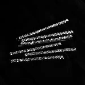 Détail d'un lot de 6 barrettes argentées ornées de strass brillants sur soie noire