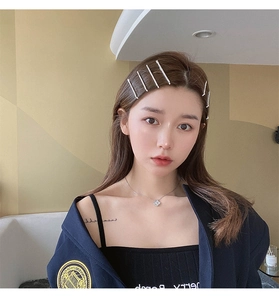 Détail de barrettes en strass argentées et collier trèfle sur un mannequin