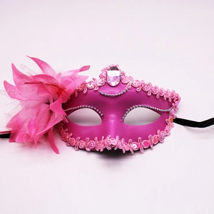 Detail of fuchsia masquerade mask with vibrant feathers, sequins and center gemstone