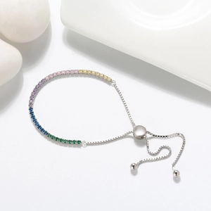 Close-up of adjustable silver bracelet with colorful rainbow cubic zirconia and toggle clasp