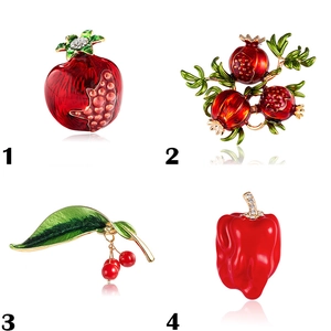 Detail of enamel fruit brooches showing pomegranate, cherry, and chili pins with crystals
