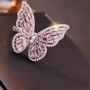 Macro shot of silver butterfly ring with pink crystals and shimmering cubic zirconia
