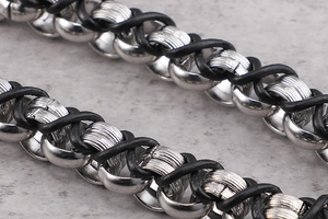 Macro shot of silver metal rings woven with black leather cord for vintage punk bracelet