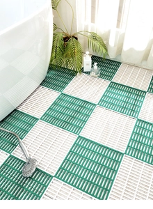 Detail of green and white TPE interlocking bathroom mats with non-slip mesh design