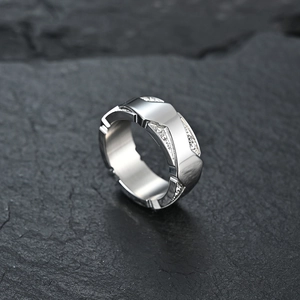 Modern titanium steel ring with sparkling crystals on textured dark stone background