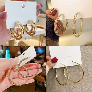 Macro shot of four gold hoop earring styles with S925 silver needles on display cards