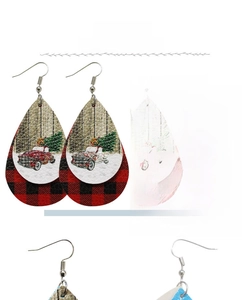 Détail de boucles d'oreilles en cuir en forme de larme avec motif de Noël écossais