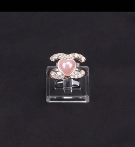 Dettaglio anello in oro rosa con gemma a cuore rosa e montatura con cristalli