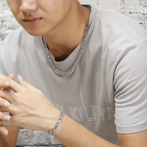 Men's silver Figaro chain necklace and bracelet set shown on model for street style