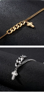 Detail of polished stainless steel cross pendant with zircon inlay on snake chain