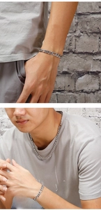 Detail of silver Figaro chain necklace and bracelet set shown on model in urban style