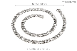 Macro view of polished 8mm stainless steel Figaro chain necklace for men on white background