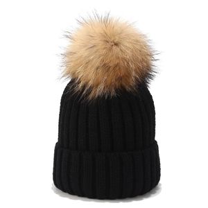Schwarze Strickmütze mit großem Echtfell-Bommel für Damen und Herren im Winterurlaub