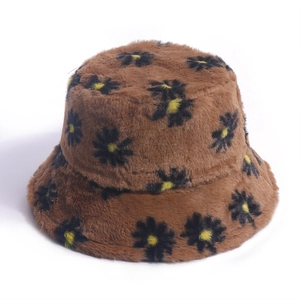 Dettaglio di un cappello a secchiello in peluche marrone con ricamo a margherita
