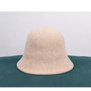Close-up of beige knit bucket hat featuring vertical ribbed chenille texture and wavy brim