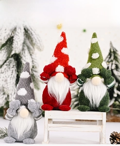 Close-up of three handmade Christmas gnomes with polka dot hats on a small wooden bench