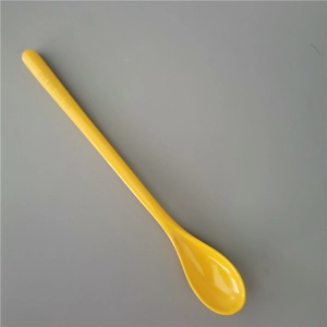 Top view of a long-handle yellow melamine spoon for dessert and milkshakes