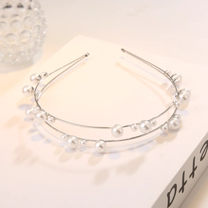Macro view of double layer pearl headband with silver metal rings and glossy white beads