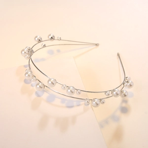 Detailed view of elegant double-layered silver metal headband with staggered pearls