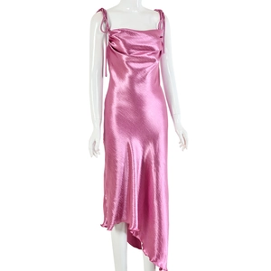 Détail de la robe nuisette en satin rose avec ourlet asymétrique et bretelles à nouer