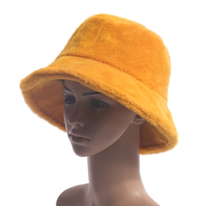 Detailed texture of thick orange faux fur winter bucket hat for women on mannequin