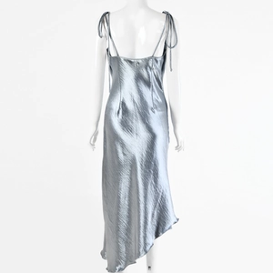 Détail de la robe en satin gris argenté montrant le dos nu et les bretelles nouées