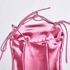 Détail d'une robe en satin rose avec col bénitier et fines bretelles réglables